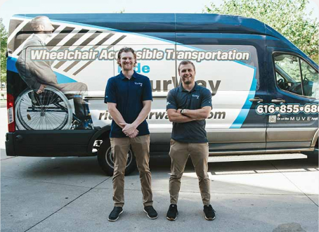 Two Employees In Front Of Nemt Vehicle