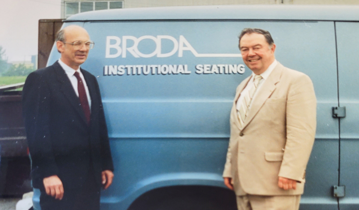 Two Executives Standing In Front Broda Van