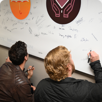 Two Men Signing Whiteboard