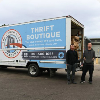 Two Men Standing In Front Of Donation Truck