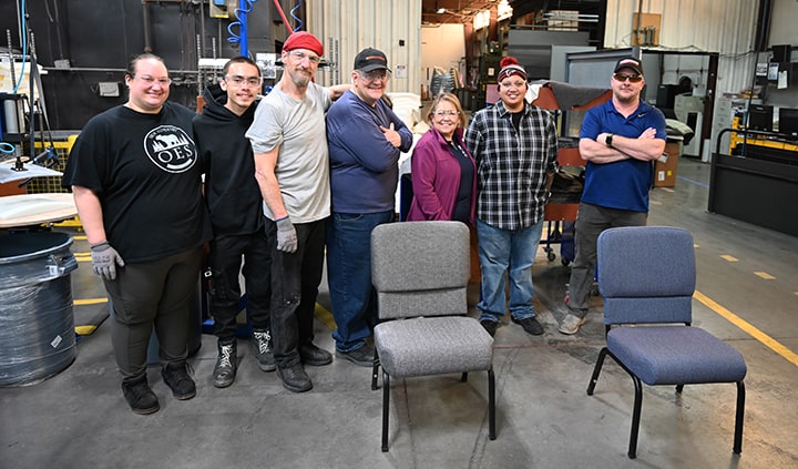 Employees surrounding Impressions church chairs